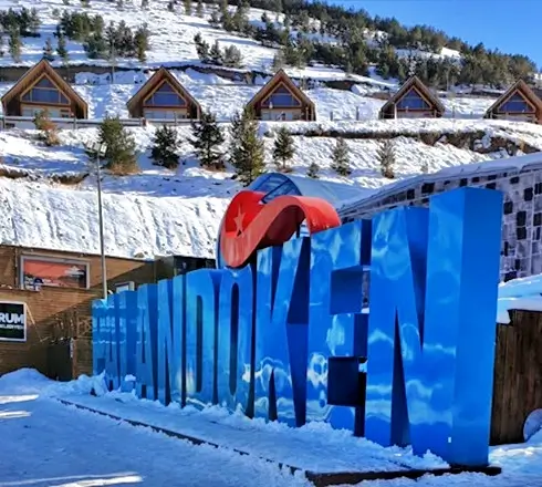 Palandöken Kayak Merkezi giriş alanı ve arka planda karla kaplı dağ evleri